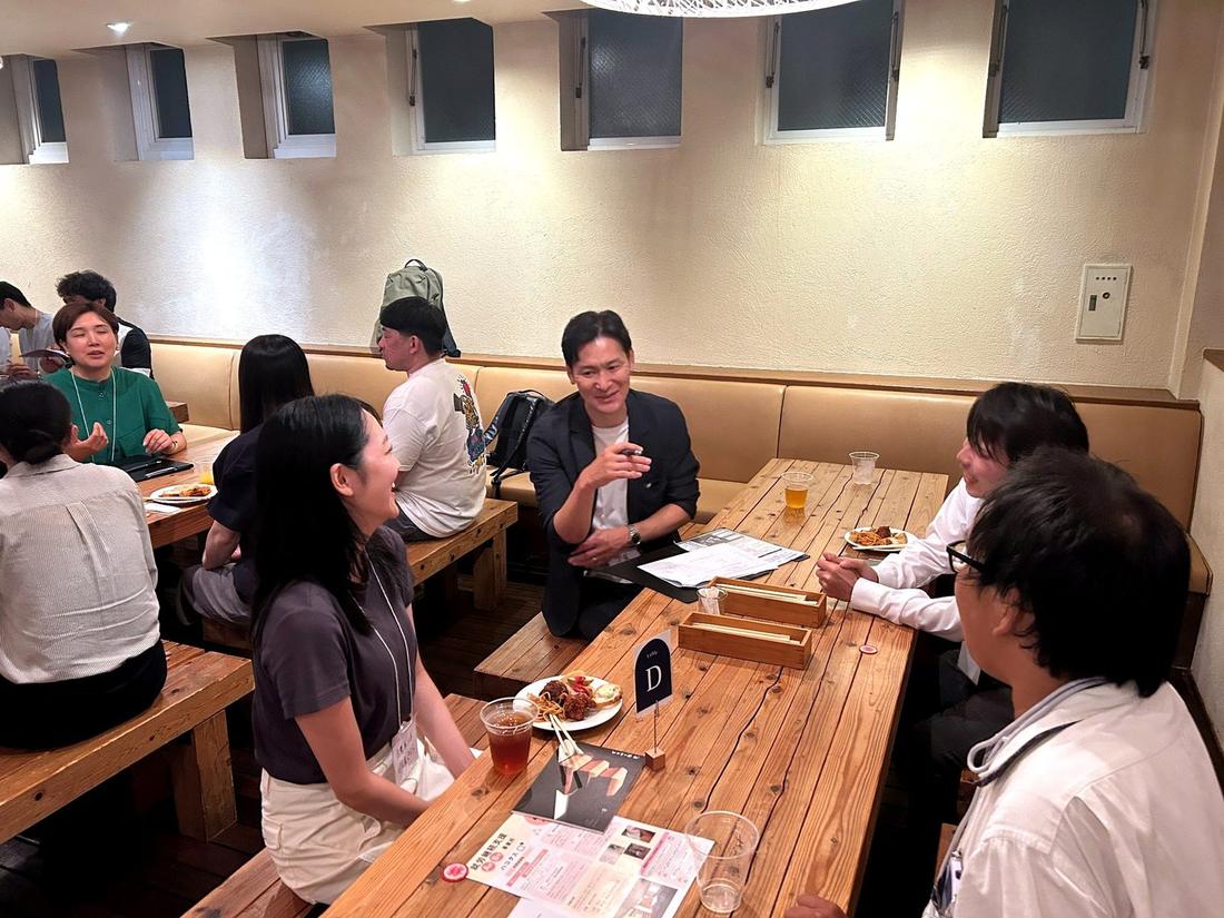 テーブルを囲んで語り合う参加者と経営層